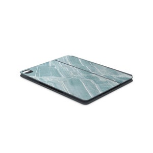 May include: A teal blue tablet case with a marble pattern. The case is closed and has a dark gray border.