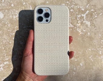 May include: A white woven phone case for an iPhone.