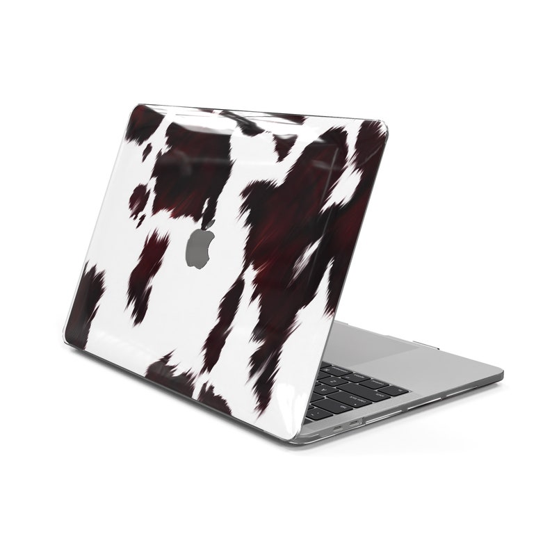 May include: A laptop computer with a white and black cowhide pattern on the lid. The laptop is closed and the lid is facing the camera.