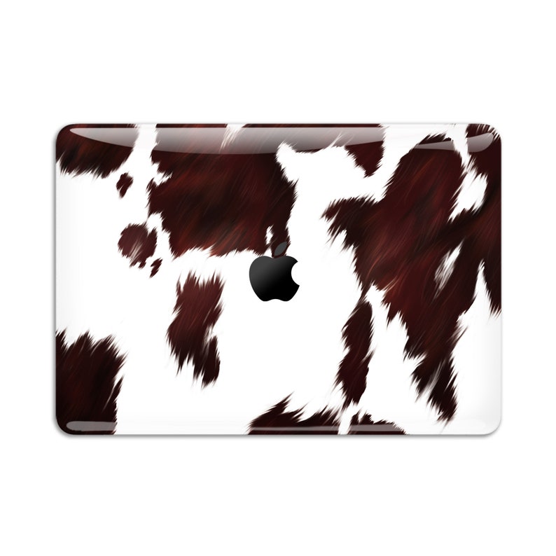 May include: A white laptop skin with a brown and white cowhide pattern. The Apple logo is visible in the centre of the skin.