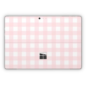 May include: A pink and white gingham pattern skin for a Microsoft Surface tablet.