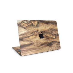 a laptop with a wood grain texture on its cover, featuring a black Apple logo in the center.