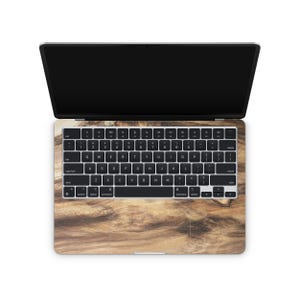 an open laptop with a wood grain-patterned keyboard cover.