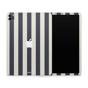 Può includere: Un iPad Pro Apple con un design a righe verticali blu navy e crema. Il logo Apple è centrato sul retro. Lo schermo è nero. La fotocamera e altre funzioni sono visibili sul retro.