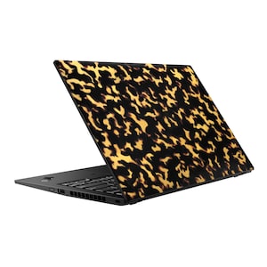 May include: Black laptop with a tortoiseshell pattern on the lid.