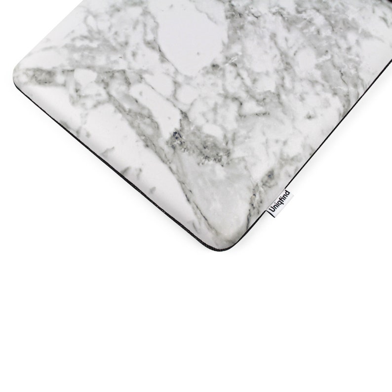 Puede incluir: Funda para port&aacute;til de m&aacute;rmol blanco con borde negro y la palabra "Uniqfind" impresa en la esquina inferior derecha.