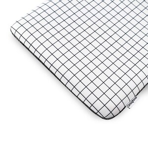 Puede incluir: Funda para port&aacute;til blanca con un patr&oacute;n de cuadr&iacute;cula negra y un logotipo negro de Uniqfind en la esquina inferior derecha.