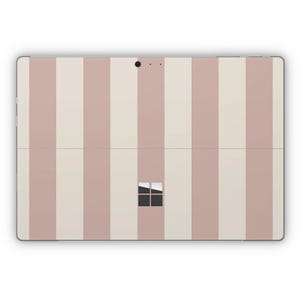 May include: A pink and white striped laptop skin with a black Microsoft logo.