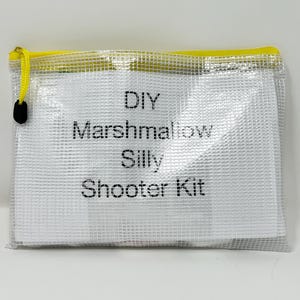 May include: A clear plastic zippered pouch with a yellow zipper and a white label that says "DIY Marshmallow Silly Shooter Kit".