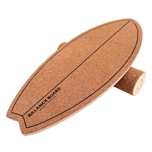 Puede incluir: Una tabla de equilibrio de corcho con forma de tabla de surf y un rodillo cilíndrico. La tabla tiene un contorno negro y el texto "BALANCE BOARD" impreso. La tabla está diseñada para el entrenamiento del equilibrio.