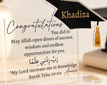 May include: A clear acrylic plaque featuring a black graduation cap topper with gold text reading Khadiza. The plaque displays the text Congratulations, You did it!, a prayer in English and Arabic, and the citation Surah Taha 20:114 with gold tassel.