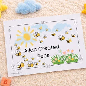 May include: A children's book titled "Allah Created Bees" with bee illustrations, a sun, and flowers. Toys surround the book, including a plush bunny, star-shaped toys, and colourful blocks.