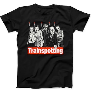 May include: A black short-sleeved t-shirt featuring a monochromatic graphic of five characters from the film Trainspotting. Above each character is a numbered label: 1 Begbie, 2 Diane, 3 Sick Boy, 4 Spud, 5 Renton. The word Trainspotting is in white text.