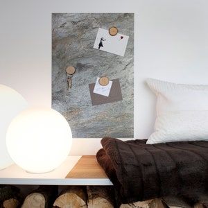 May include: A brown faux fur throw blanket on a white shelf with two white globe lamps. A slate-colored magnetic board with wooden round magnets holding keys, a postcard, and a note.