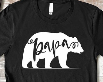 May include: Black t-shirt with a white silhouette of a bear with the word "papa" written inside the bear.