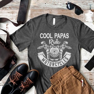 May include: A gray t-shirt with a white graphic of a motorcycle and the text "Cool Papas Ride Motorcycles".