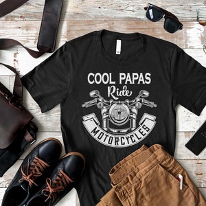 May include: Black t-shirt with a white graphic of a motorcycle and the text "Cool Papas Ride Motorcycles".