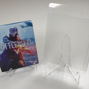 Puede incluir: Una taza de cerámica blanca con un asa negra y el texto "But First, Coffee" en un estilo manuscrito. La taza está sobre una superficie blanca. La taza mide 10 cm de alto.