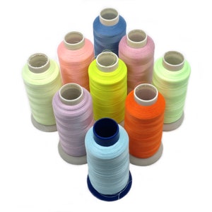 May include: A set of ten spools of thread in various pastel colours, including light blue, pink, yellow, green, orange, and lavender. The spools are arranged in a circle on a white background.