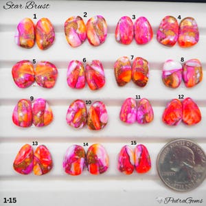May include: Fifteen pairs of polished, teardrop-shaped cabochons labeled Star Brust 1-15, featuring vibrant swirls of hot pink, orange, and white with metallic copper veining. A United States quarter coin is included for scale next to pair 15.