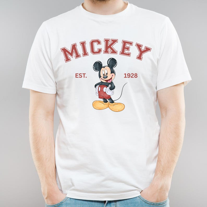 May include: White t-shirt with a red and black Mickey Mouse graphic. The text "Mickey" is in a red arch above the graphic. The text "Est. 1928" is in red below the graphic.