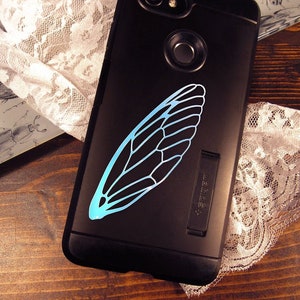 May include: A black phone case with a blue cicada wing design. The case has a kickstand on the back.