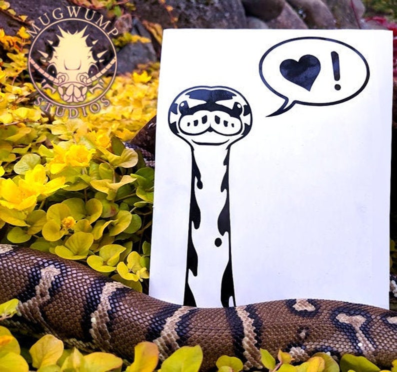 May include: Black and white sticker of a cartoon snake with a heart and exclamation point speech bubble. The snake has a long neck and a cute face. The sticker is on a white background.