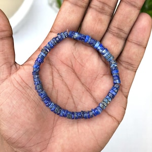 Op de afbeelding: Een blauwe lapis lazuli kralen armband met een vierkante vorm. De armband is gemaakt van natuurlijke stenen en is ongeveer 18 cm lang.