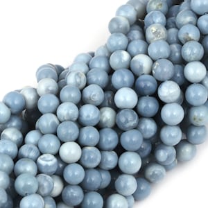 May include: A strand of light blue opal beads. The beads are round and smooth, with a slightly iridescent finish.