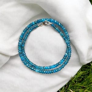 Puede incluir: Un delicado collar hecho de cuentas de apatita azul. El collar está en capas y tiene un cierre plateado.