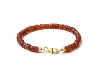May include: A brown gemstone bracelet with a gold clasp.