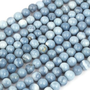 May include: A strand of light blue opal beads. The beads are round and smooth, with a slightly iridescent finish.