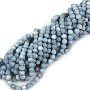 May include: A strand of light blue opal beads. The beads are round and smooth, with a slightly iridescent finish.