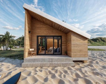 May include: A modern, wooden beach house with a slanted roof and large glass doors. The house is set on a sandy beach with palm trees and a surfboard in the foreground. The sky is blue with some clouds.