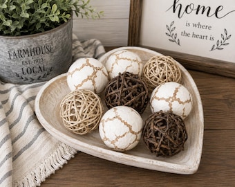 May include: A heart-shaped wooden tray containing a collection of decorative spheres. The set includes white spheres with a brown crackled texture, dark brown woven twig spheres, and light tan woven rattan spheres arranged in a cluster.