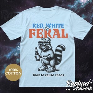 Peut inclure: Un t-shirt bleu clair avec un graphique d'un raton laveur portant une casquette de baseball "USA" rouge, blanche et bleue, des lunettes de soleil et tenant une bouteille de bi&egrave;re et un hot-dog. Le texte "RED, WHITE & FERAL" est au-dessus du raton laveur et le texte "Born to cause chaos" est en dessous du raton laveur.
