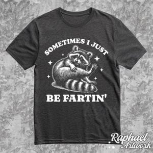 Pode incluir: Uma camiseta cinza escura com um gr&aacute;fico branco de um guaxinim e o texto "Sometimes I Just Be Fartin'" impresso na frente.