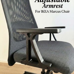 Könnte beinhalten: Nahaufnahme eines schwarzen Bürostuhls mit verstellbaren Armlehnen. Der Stuhl hat eine graue Sitzfläche und Rückenlehne mit einem oberen Rückenteil aus Mesh. Der Text auf dem Bild lautet "Adjustable Armrest For IKEA Marcus Chair."