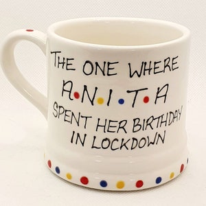 May include: White ceramic mug with a handle and the text "The One Where Anita Spent Her Birthday in Lockdown." The mug has a series of colored dots around the bottom and on the handle.