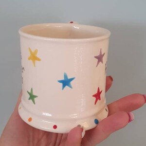 Puede incluir: Taza de cer&aacute;mica blanca con un patr&oacute;n de estrellas de colores y el texto "You are my sunshine" en el lateral.