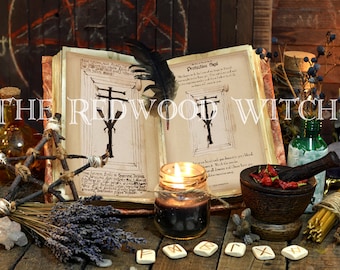 Op de afbeelding: Een mystieke scène met een open boek met illustraties, brandende kaarsen, kruiden en een veer. De tekst "THE REDWOOD WITCH" staat bovenaan de afbeelding. De scène is op een houten oppervlak geplaatst.