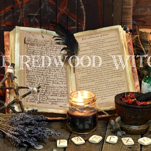 May include: An open book with handwritten text, a feather quill, and lit candles are featured in this image. Other items include a mortar and pestle, bottles, crystals, and the text "THE REDWOOD WITCH". The scene evokes a mystical theme.