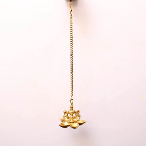 May include: A gold hanging oil lamp with a chain and five wicks. The lamp is designed in a traditional style with a decorative top and a lotus flower base.