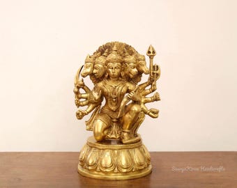 May include: A gold-colored brass statue of a Hindu deity with multiple arms and heads. The deity is seated on a lotus-shaped base.
