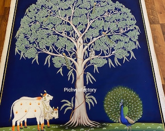 Puede incluir: Una pintura tradicional india sobre lienzo que representa un gran árbol con monos, pájaros y un pavo real. Dos vacas blancas se encuentran debajo del árbol, y la escena se desarrolla sobre un fondo azul con un borde de flores de loto y peces.