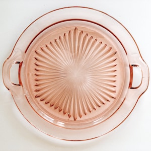 Pink Depression Glass Handled Cake-plate with starburst pattern.