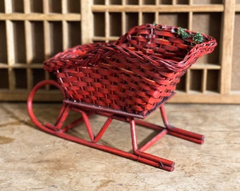 Vintage red wicker sleigh with knows and poinsettias