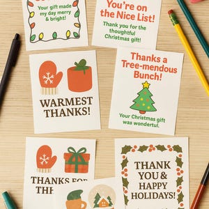 May include: A collection of Christmas-themed thank you cards with various designs and messages. The cards feature festive illustrations like a Santa hat, Christmas tree, mittens, and snow globes. Text includes "Thank You So Much!" and "Happy Holidays!"