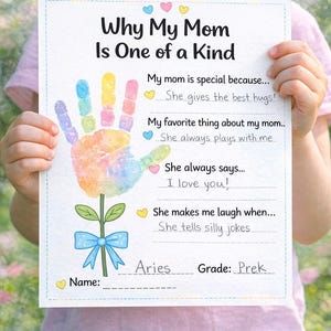 Peut inclure: Un enfant tient une feuille de papier blanche avec le texte "Why My Mom Is One of a Kind". Le papier présente une empreinte de main colorée, une fleur avec un nœud bleu et des invites à compléter sur la maman de l'enfant.