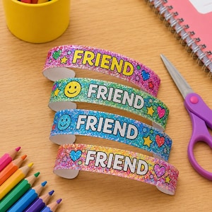 Könnte beinhalten: Vier glitzernde, gebogene Armbänder mit dem Wort FRIEND in fetten schwarzen Buchstaben. Jedes Band zeigt bunte Muster mit Smileys, Herzen und Sternen in glitzernden Rosa-, Grün-, Blau- und Orangetönen mit einer funkelnden Textur.